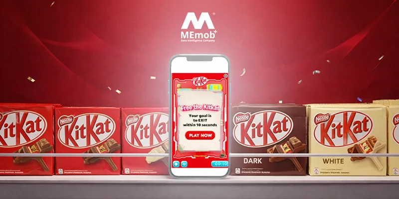 A smartphone showing a game where the goal is to "Free the KitKat" within 10 seconds, alongside a variety of KitKat chocolate bars (Milk, Dark, White) on a shelf, with the MEmob+ logo visible at the top.