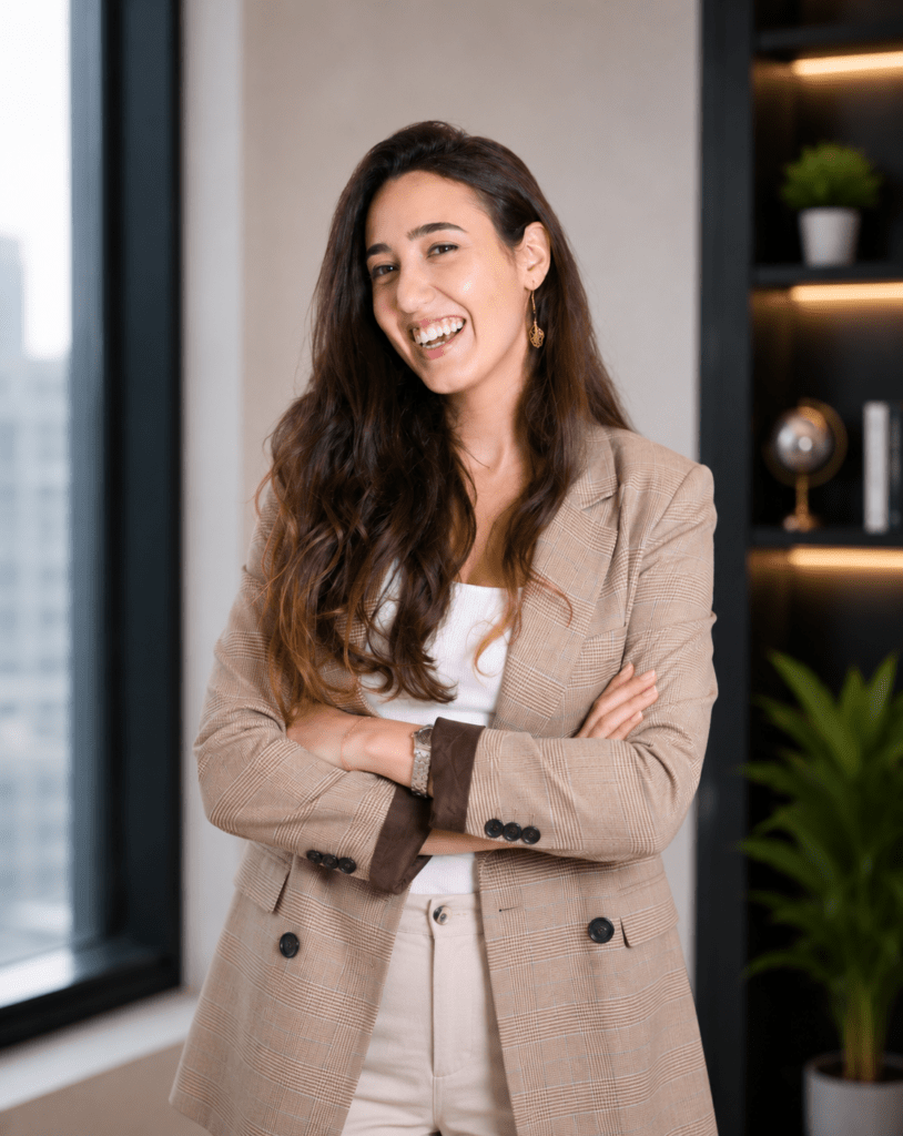 Professional portrait of Rayya Salman, Regional Manager of Business Development at MEmob, standing with folded arms in a modern office.